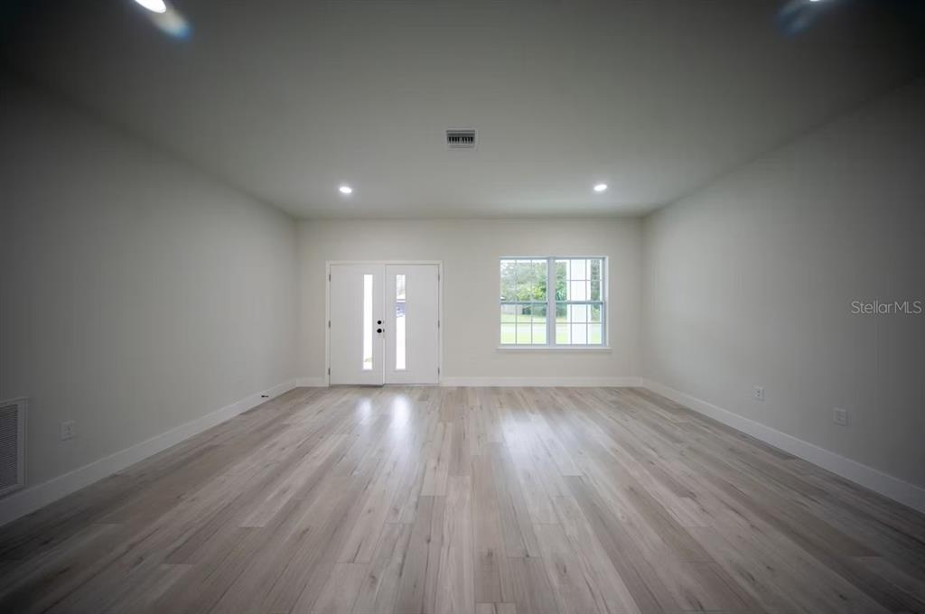 6442 North Sandborn Loop Citrus Springs, FL 34433 - Photo 8 of 33 an empty room with wooden floor and windows