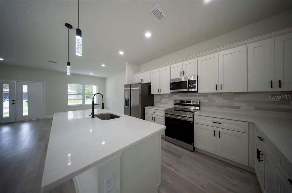 6442 North Sandborn Loop Citrus Springs, FL 34433 - Photo 9 of 33 a kitchen with stainless steel appliances a sink stove and cabinets