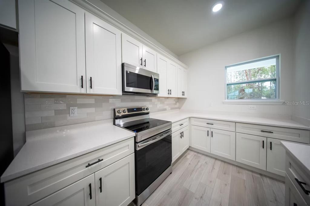 6442 North Sandborn Loop Citrus Springs, FL 34433 - Photo 10 of 33 a kitchen with cabinets appliances a sink and a window