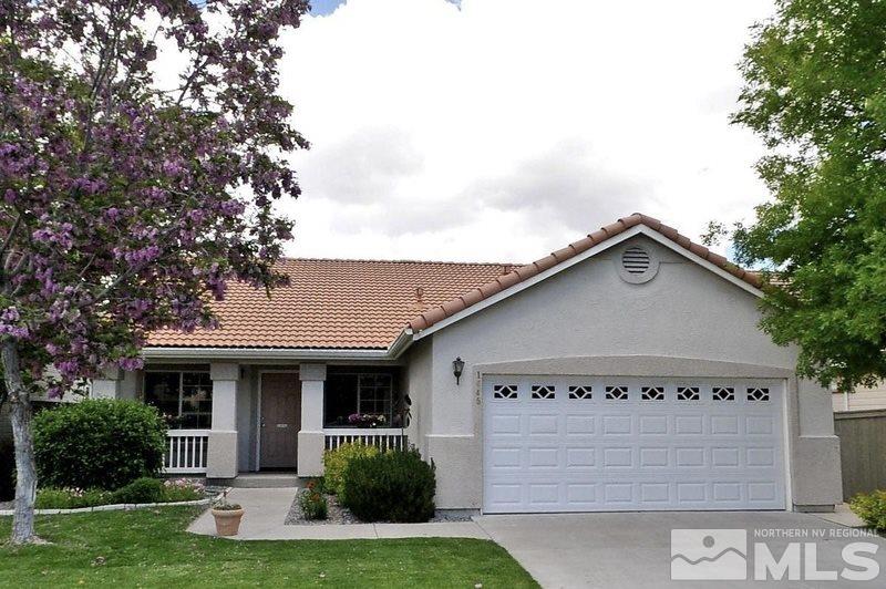 1645 Westmont Lane Reno, NV 89521 - Photo 1 of 16 a view of a white house with a yard potted plants and a large tree