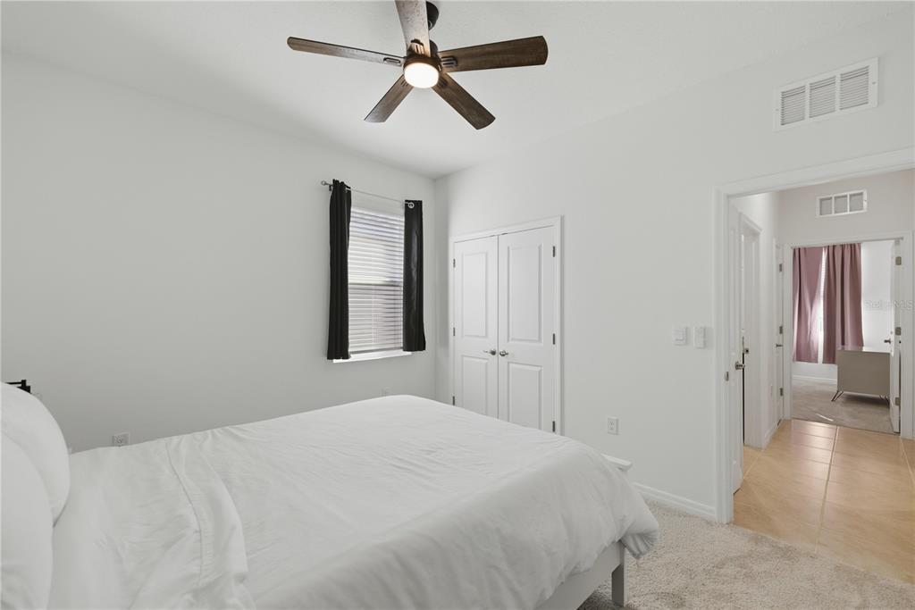 5157 Northwest 43rd Ln Road Ocala, FL 34482 - Photo 17 of 70 a bedroom with a large bed and a chandelier