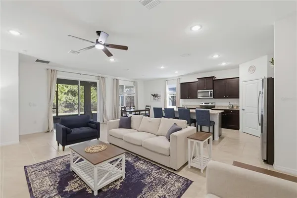 a kitchen with stainless steel appliances a stove a sink a microwave a refrigerator white cabinets and wooden floor