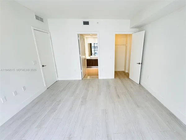 a view of a big room with wooden floor and windows