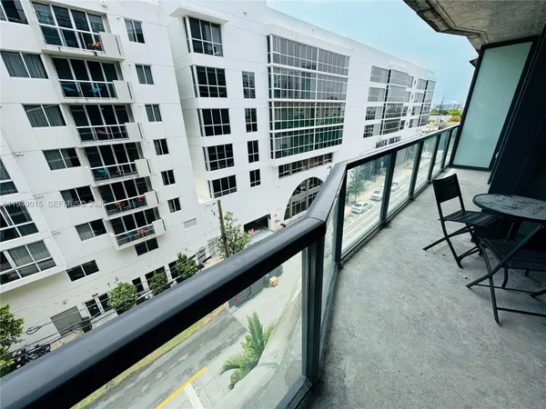 a view of balcony with wooden floor and furniture