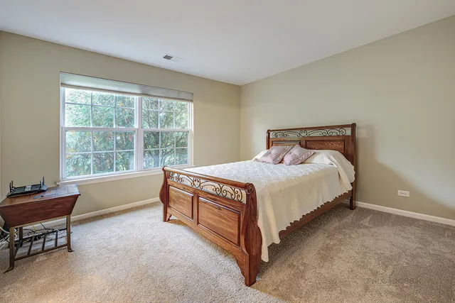 a bed sitting in a bedroom next to a window