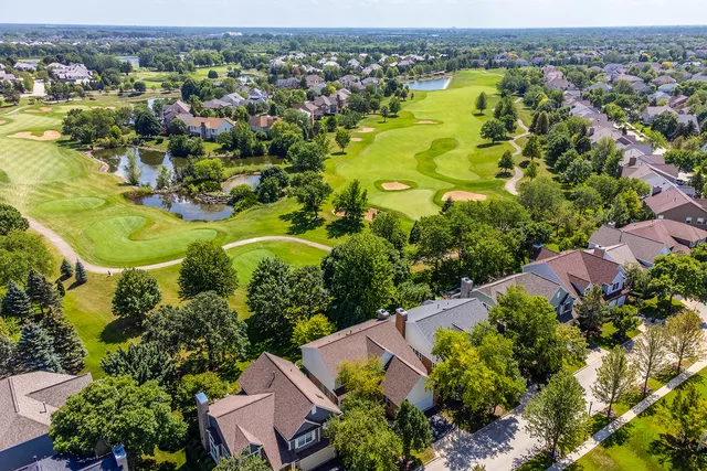 an aerial view of residential houses with outdoor space and trees