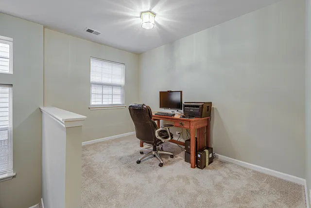 a view of a workspace with furniture and a window