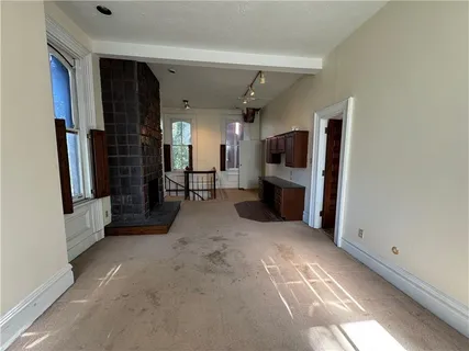 a view of a big room with windows and entryway