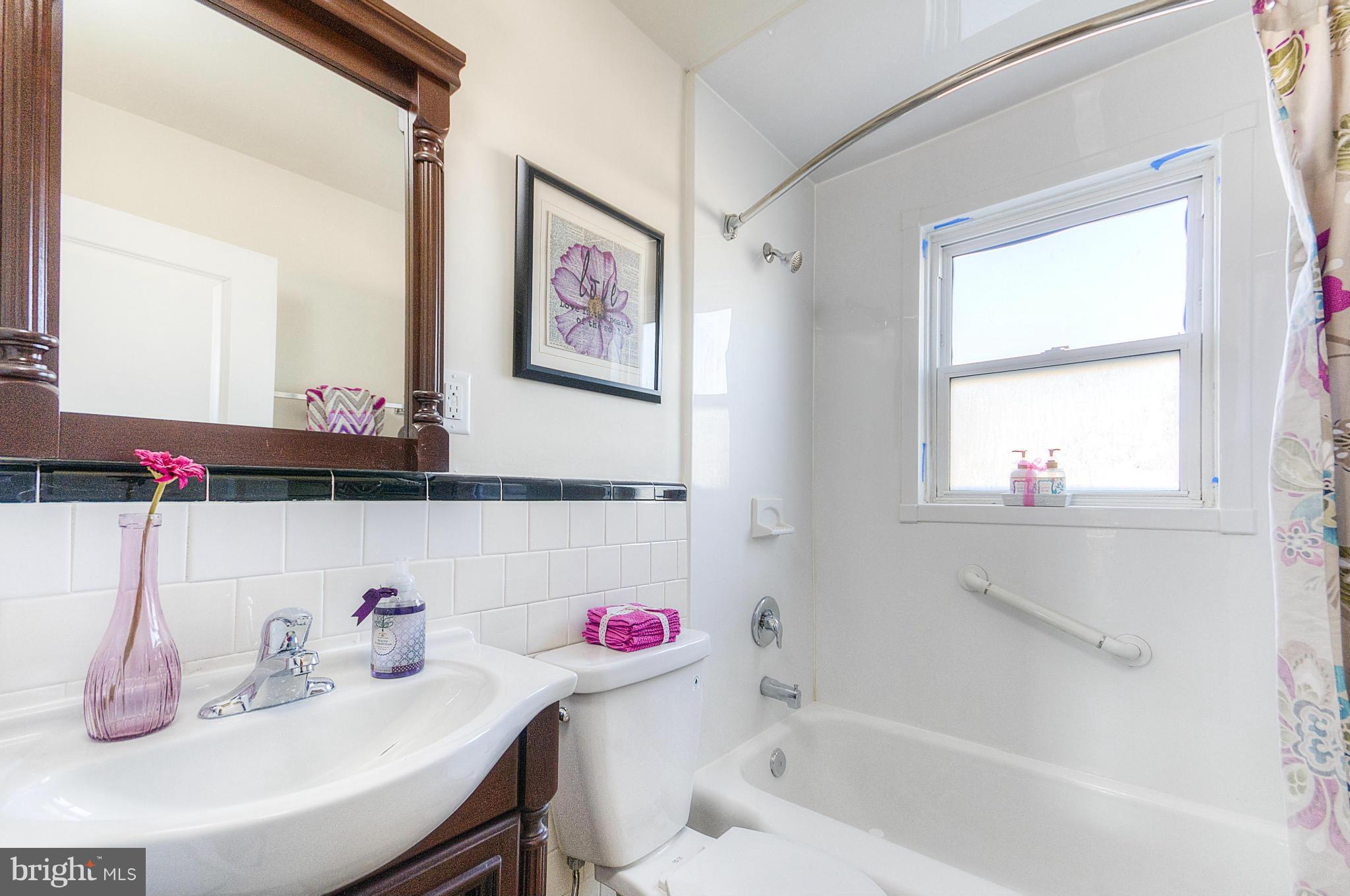 2159 Coralthorn Road Baltimore, MD 21220 - Photo 12 of 16 a bathroom with a bathtub sink vanity and window