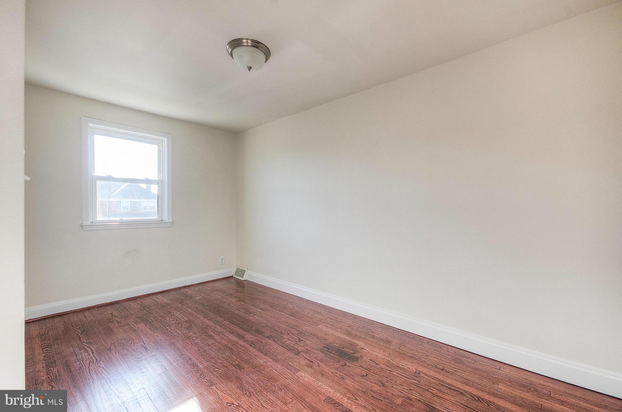 2159 Coralthorn Road Baltimore, MD 21220 - Photo 10 of 16 an empty room with wooden floor and windows