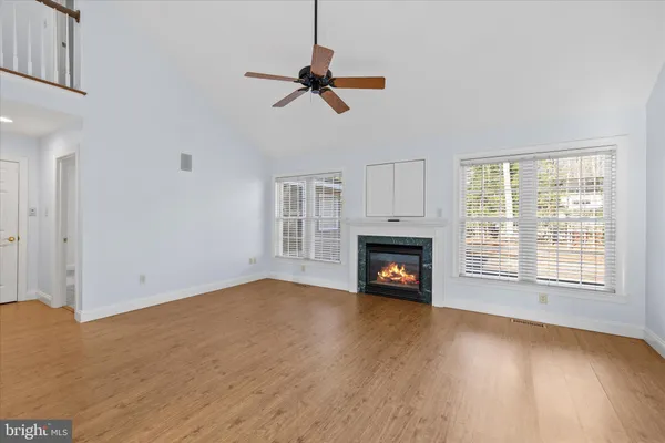 a view of an empty room with a window and fireplace