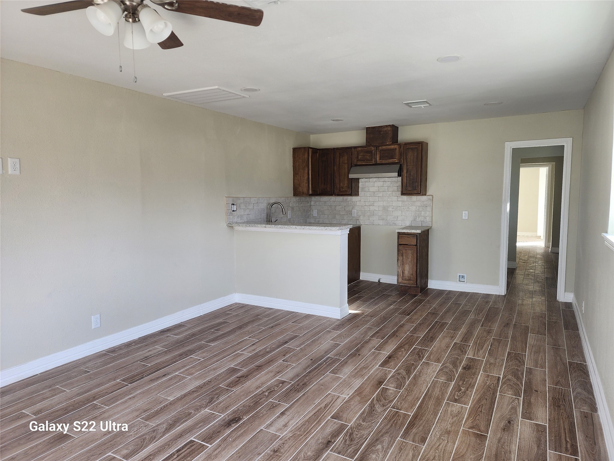 702 McDaniel Street, Unit B Houston, TX 77022 - Photo 5 of 8 wooden floor in an empty room with a kitchen
