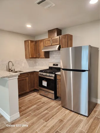 a kitchen with stainless steel appliances granite countertop a refrigerator sink and stove