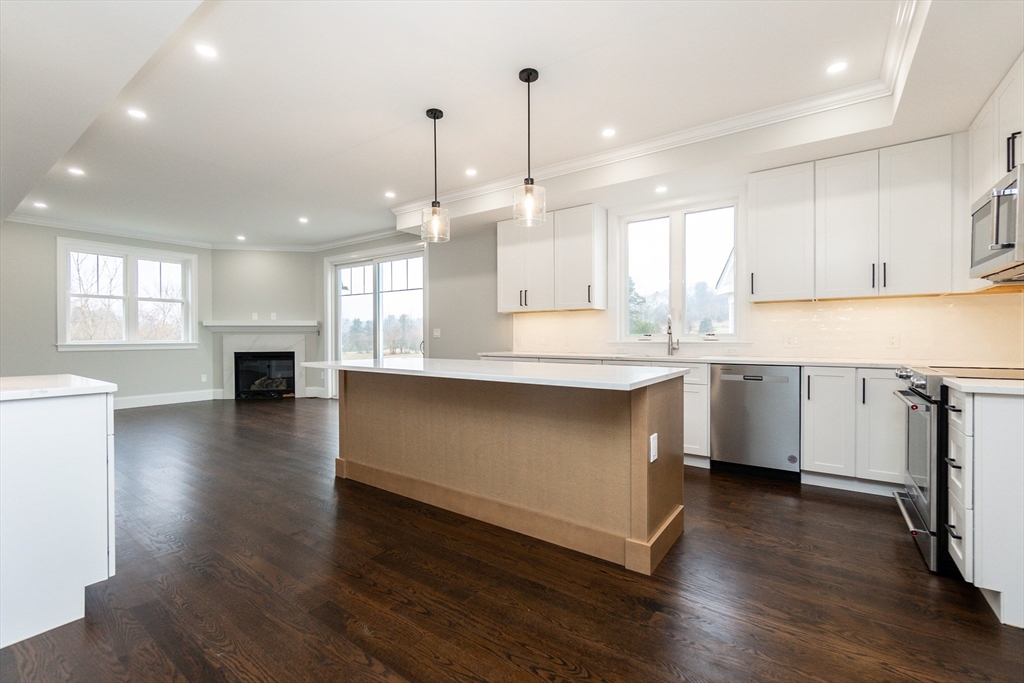 83 East Main Street Hopkinton, MA 01748 - Photo 11 of 42 a kitchen with kitchen island a stove a sink a refrigerator and a counter top space