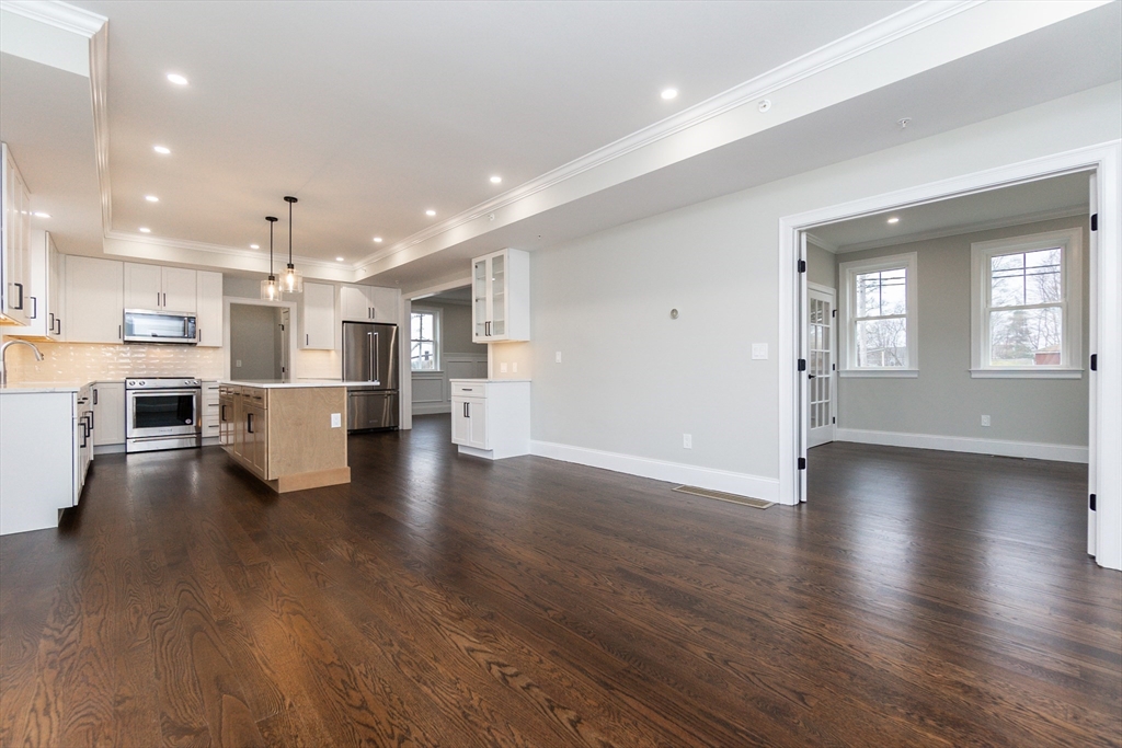 83 East Main Street Hopkinton, MA 01748 - Photo 12 of 42 an open kitchen with white cabinets wooden floor and stainless steel appliances