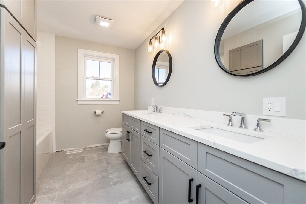 83 East Main Street Hopkinton, MA 01748 - Photo 33 of 42 a spacious bathroom with a granite countertop double vanity and a mirror