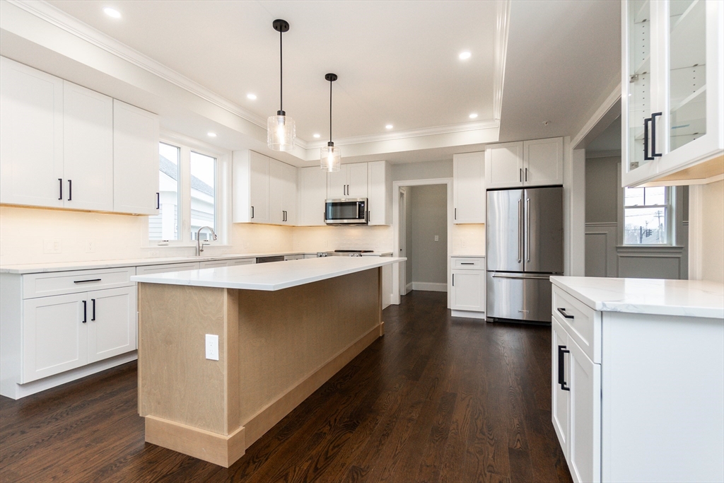 83 East Main Street Hopkinton, MA 01748 - Photo 9 of 42 a kitchen with white cabinets and stainless steel appliances