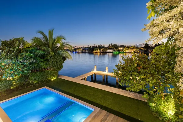 a view of a balcony with chairs and a yard