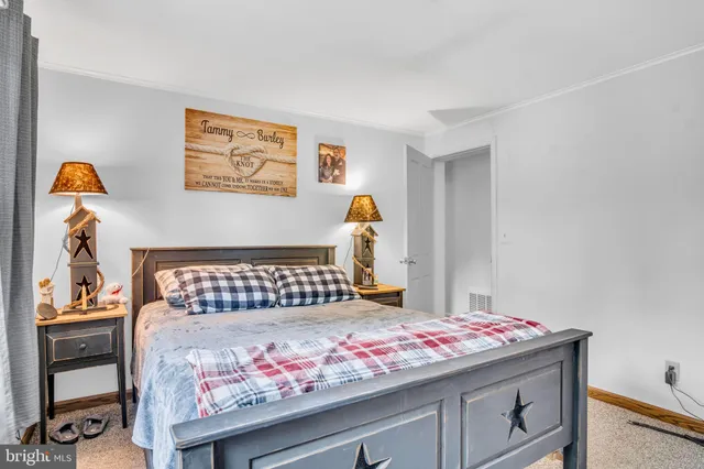 a bedroom with a bed and a lamp on dresser