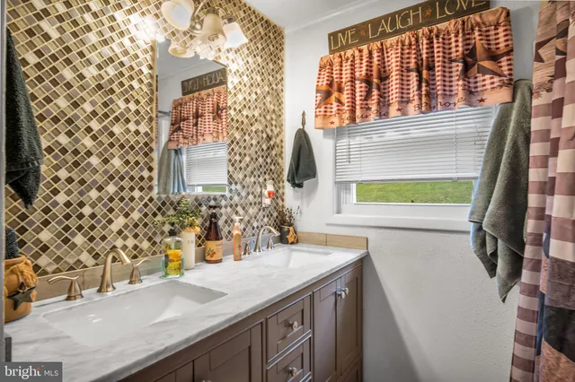 a bathroom with a granite countertop sink and a large mirror