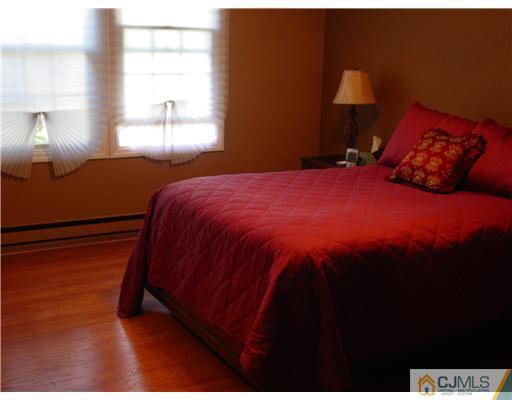 230 Convent Road Monroe Township, NJ 08831 - Photo 3 of 14 a bedroom with a bed and a lamp