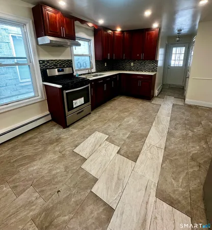 a large kitchen with stainless steel appliances kitchen island granite countertop a sink and cabinets