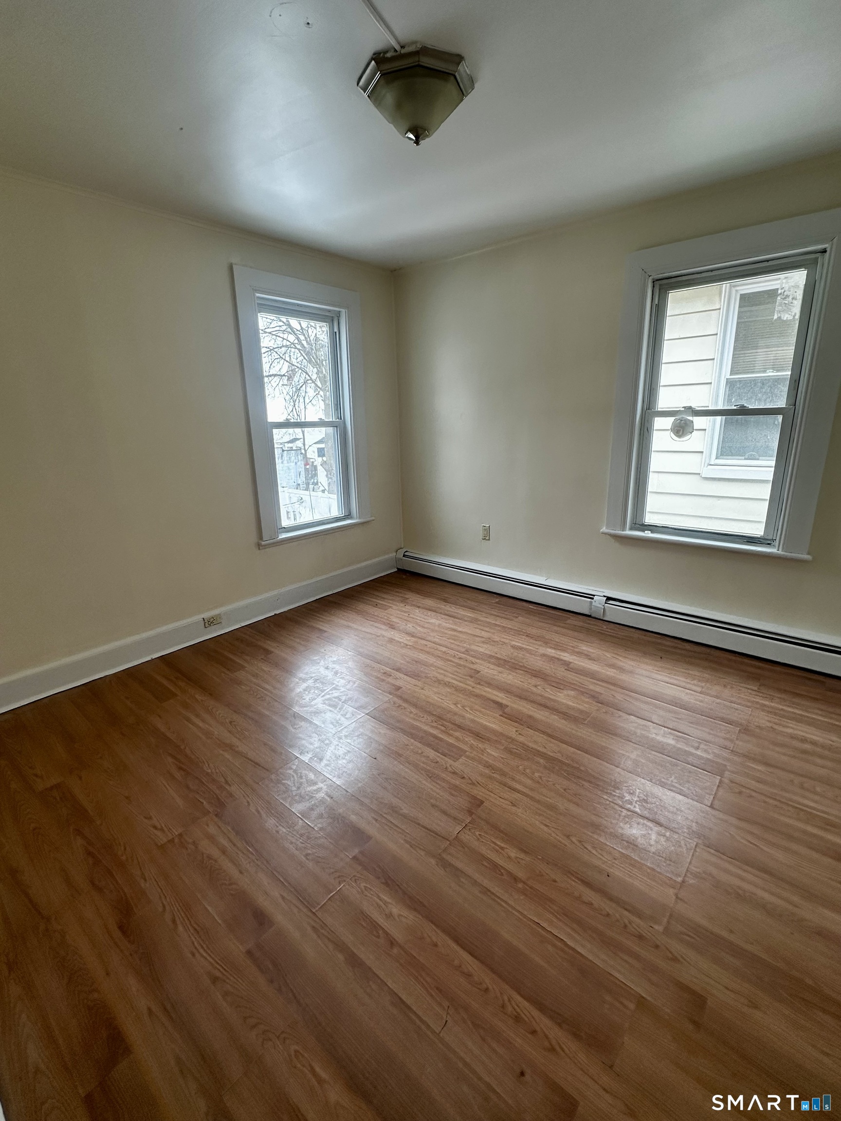 147 Helen Street, Unit 2 Bridgeport, CT 06608 - Photo 7 of 8 a view of an empty room with wooden floor and a window