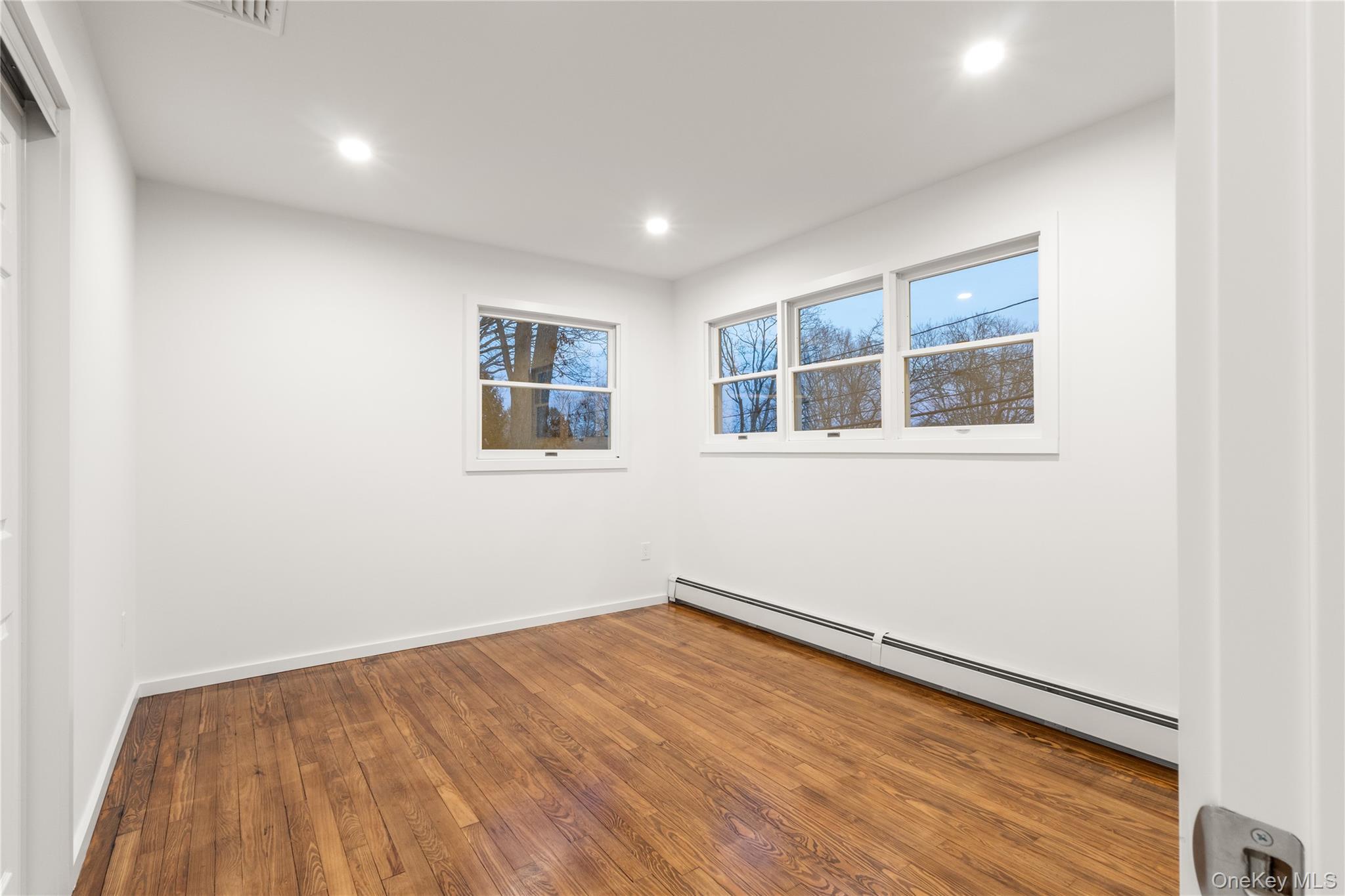 10 Overbrook Street Riverhead, NY 11901 - Photo 3 of 8 a view of empty room with wooden floor and fan