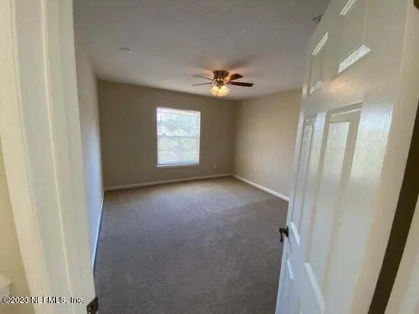 a view of a livingroom with a ceiling fan and window