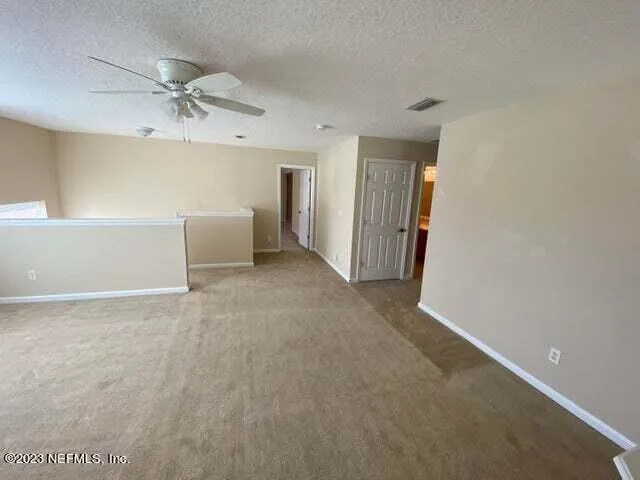 a view of room with windows and refrigerator