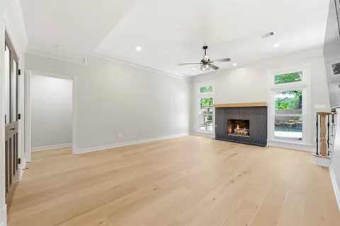 a view of a livingroom with a fireplace a ceiling fan and chandelier fan
