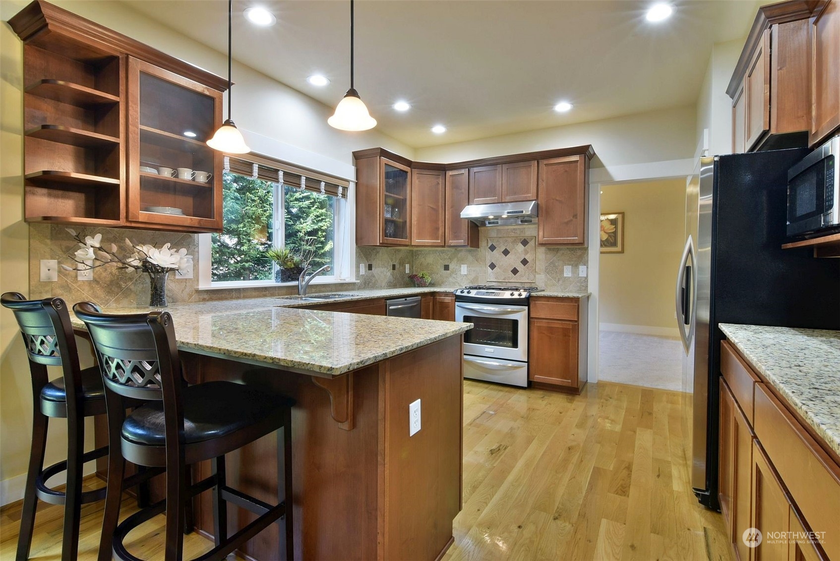12 228th Street Southeast Bothell, WA 98021 - Photo 6 of 33 a kitchen with stainless steel appliances granite countertop a sink a stove and a refrigerator