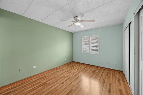 an empty room with a window and ceiling fan