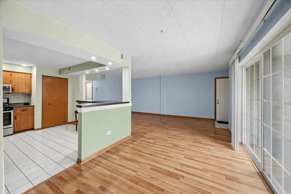 a view of a kitchen with wooden floor and a refrigerator