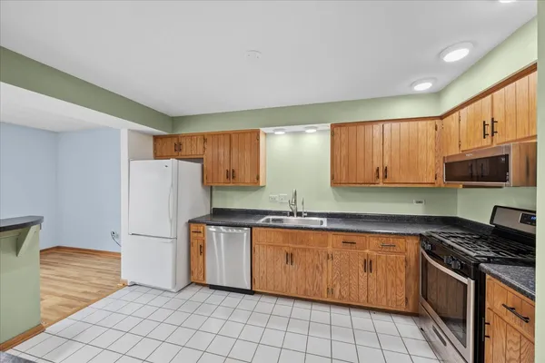 a kitchen with stainless steel appliances granite countertop a refrigerator sink and cabinets
