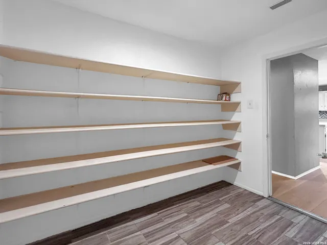 a view of walk in closet with empty racks