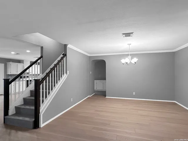 a view of an empty room with wooden floor