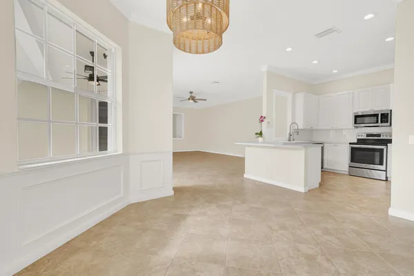 a view of kitchen with stainless steel appliances cabinets and large window