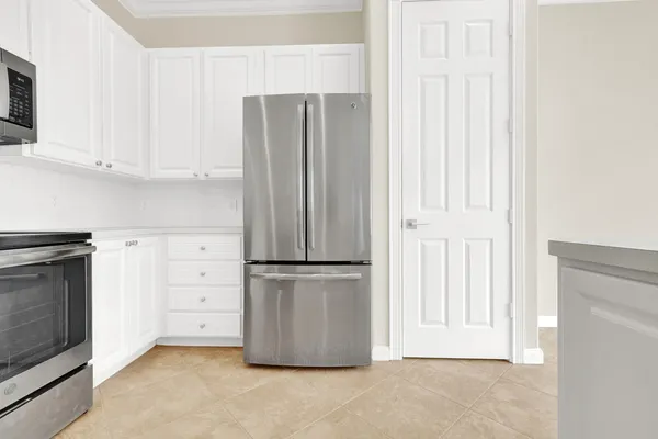 a kitchen with cabinets and a refrigerator