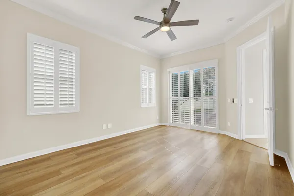 a view of an empty room with a window and wooden floor