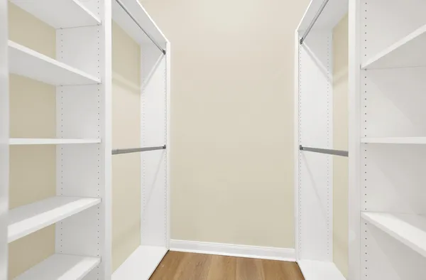 a view of walk in closet with empty racks