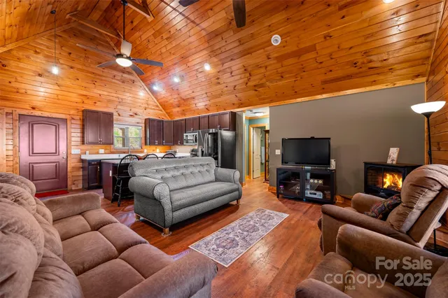 a living room with furniture a flat screen tv and kitchen view
