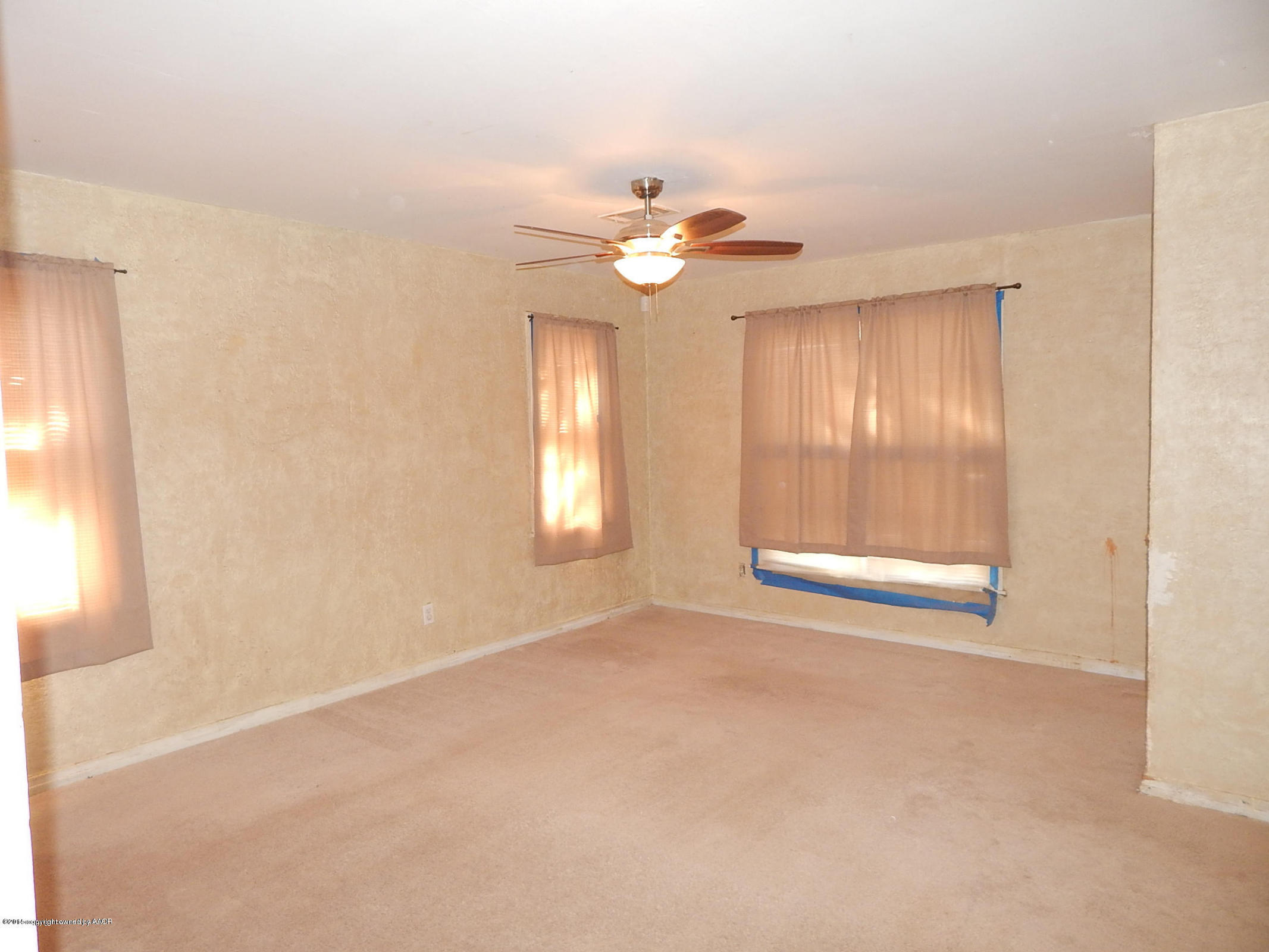 4217 South Jackson Street Amarillo, TX 79110 - Photo 3 of 13 an empty room with windows and fan