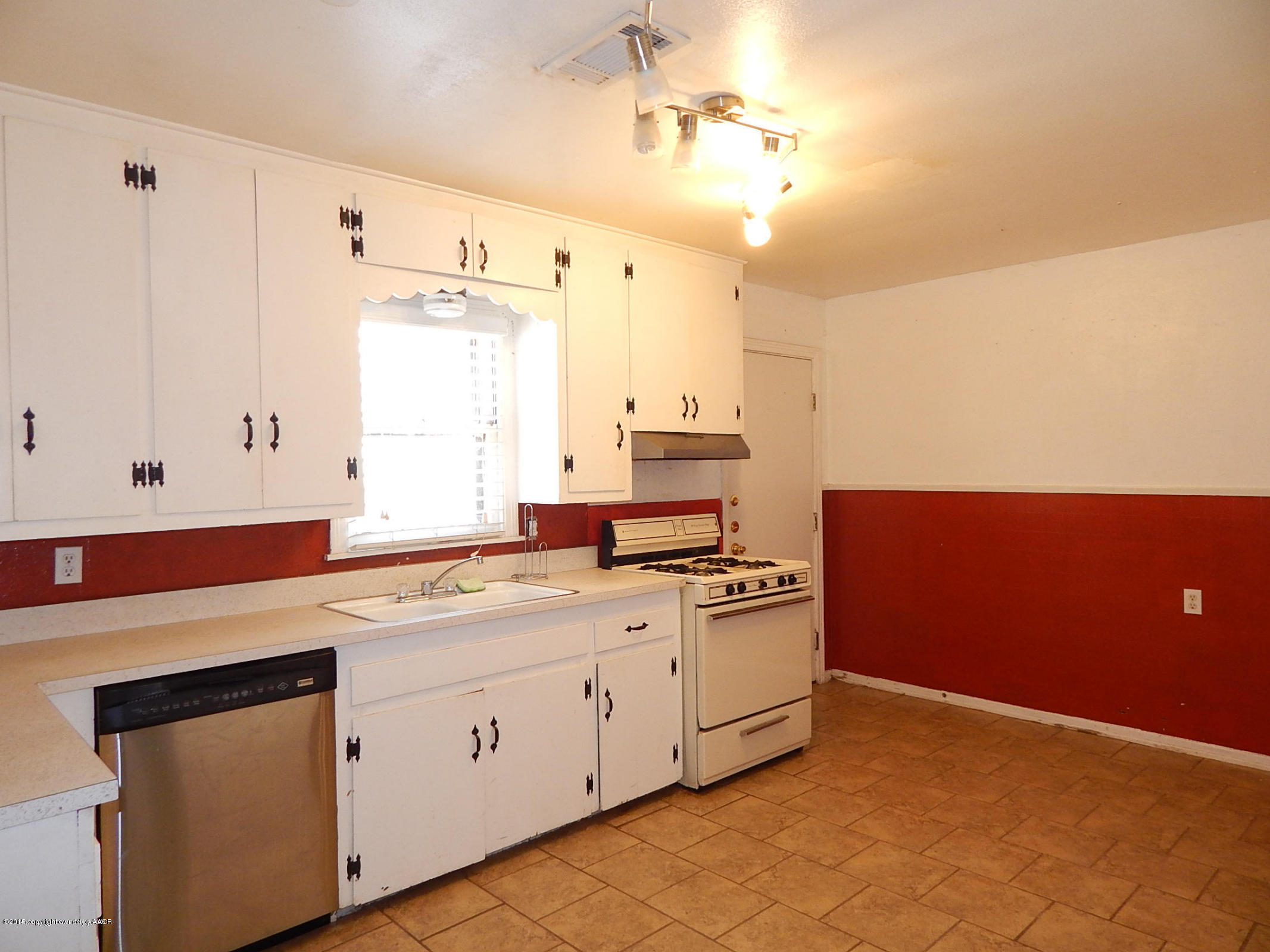 4217 South Jackson Street Amarillo, TX 79110 - Photo 5 of 13 a kitchen with a stove a sink and a window