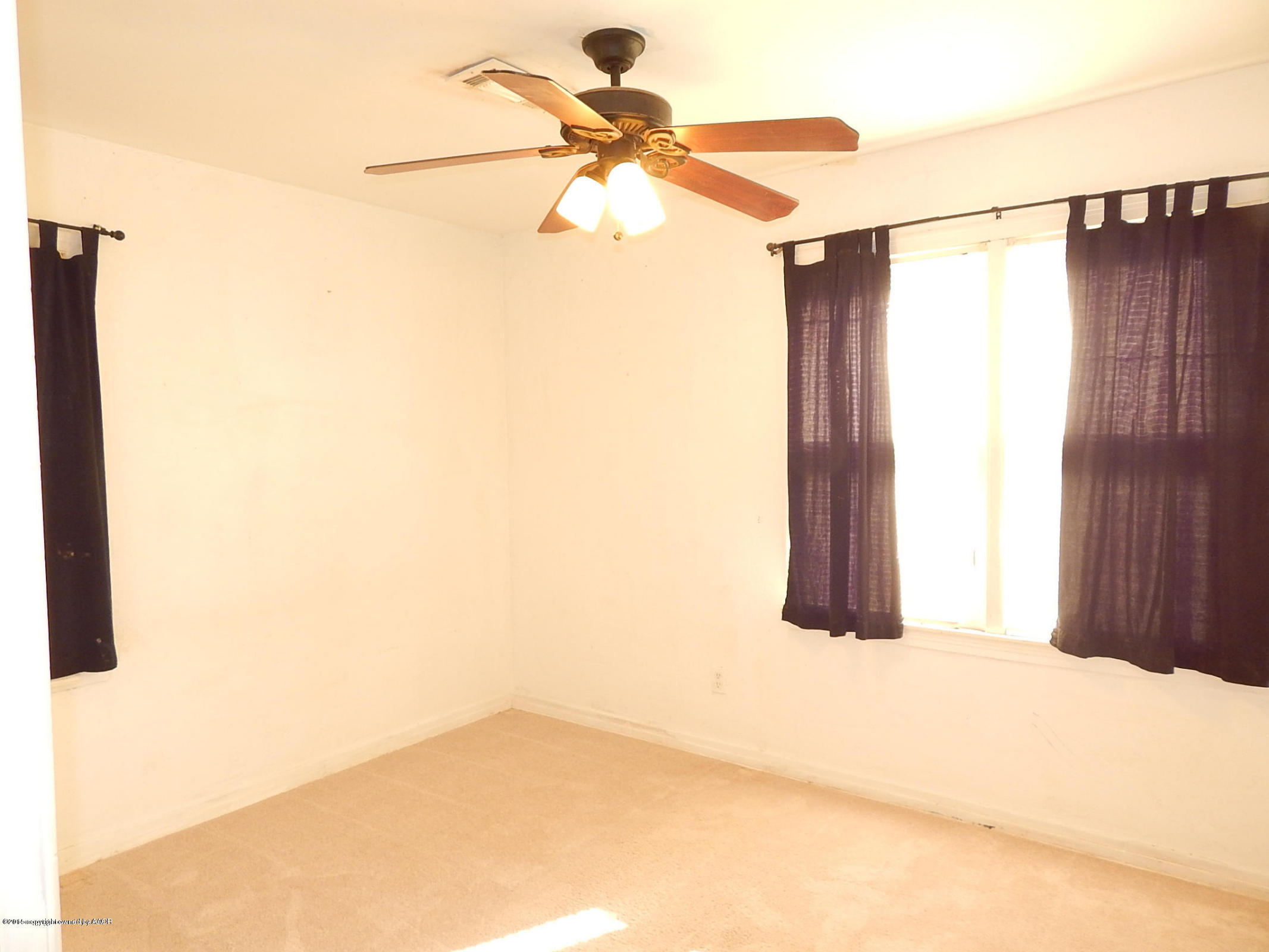 4217 South Jackson Street Amarillo, TX 79110 - Photo 9 of 13 a view of a room with a chandelier fan and a window