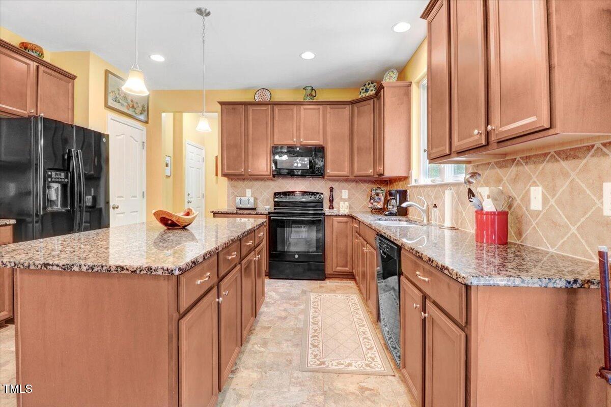 1304 Double Oak Lane Willow Spring, NC 27592 - Photo 17 of 46 a kitchen with stainless steel appliances granite countertop a stove a sink and a refrigerator