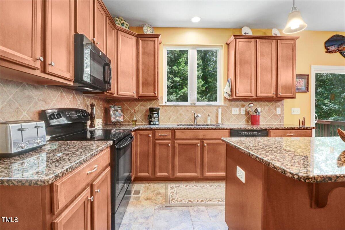 1304 Double Oak Lane Willow Spring, NC 27592 - Photo 19 of 46 a kitchen with stainless steel appliances granite countertop a sink a stove and a microwave