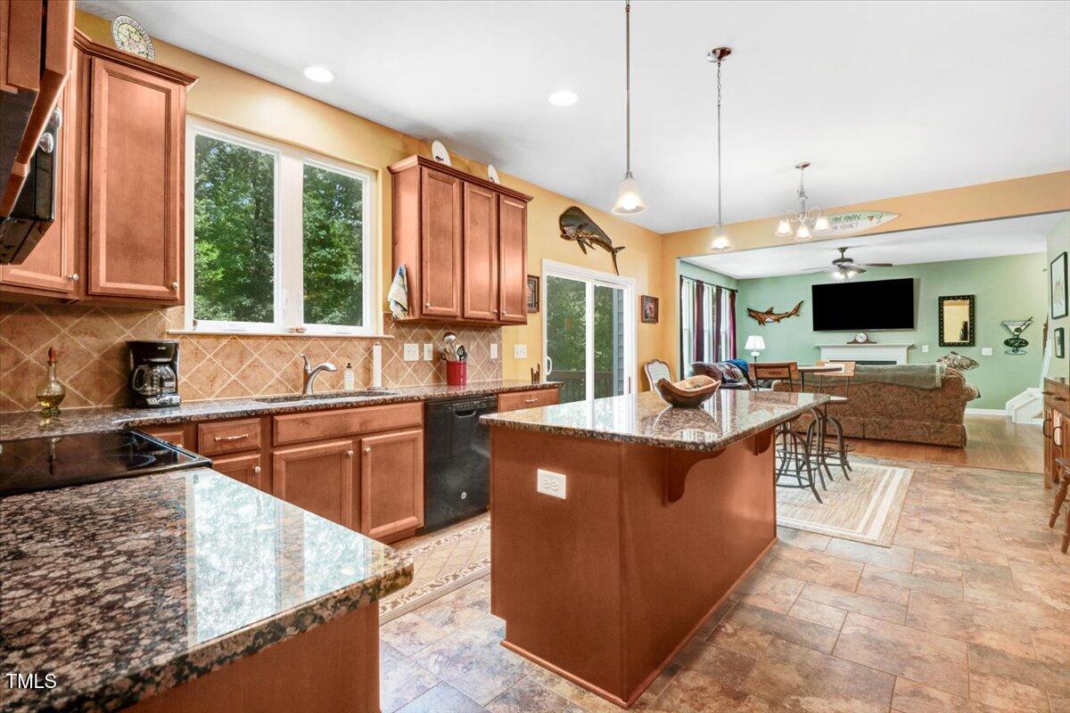 1304 Double Oak Lane Willow Spring, NC 27592 - Photo 20 of 46 a kitchen with kitchen island a large counter top space a sink a stove and a window