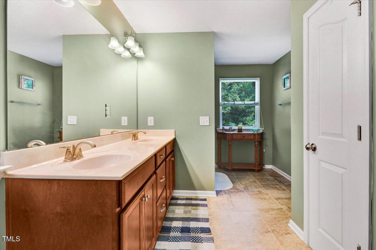 1304 Double Oak Lane Willow Spring, NC 27592 - Photo 25 of 46 a en suite bathroom with a sink and a mirror