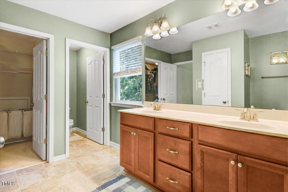 1304 Double Oak Lane Willow Spring, NC 27592 - Photo 28 of 46 a spacious bathroom with a granite countertop sink a mirror and a shower
